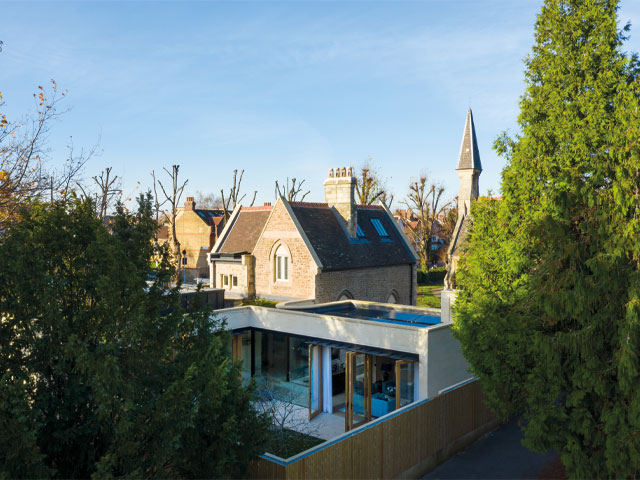 Grand Designs renovations. Rear of contemporary home steeple roof timber fence