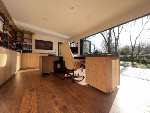 large garden office with storage and bifold doors opening onto a terrace