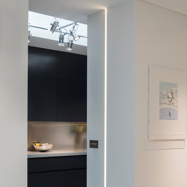 Illuminated kitchen doorway framework with architectural lighting.