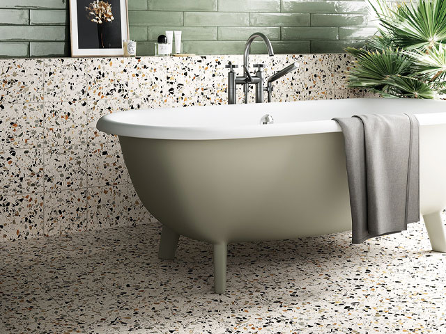 terrazzo floor and wall in front of pastel green freestanding bath