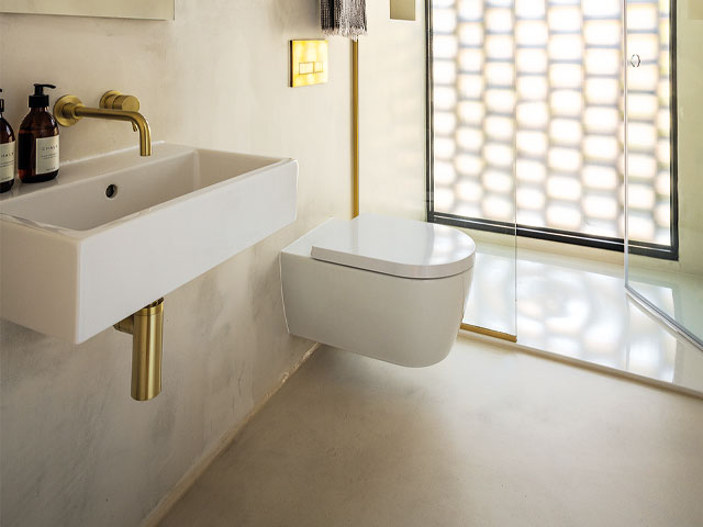 White floating toilet unit white sink and shower with gold fixtures and fittings