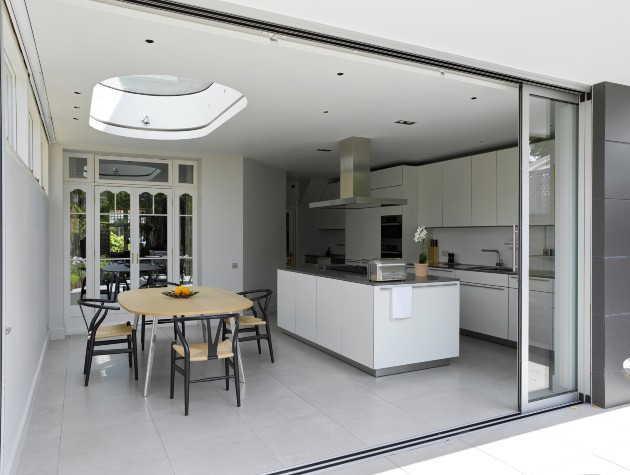 kitchen and dining area in white seen through an open sliding door