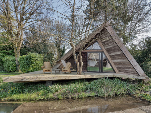 The Climbers Cabin exterior with decking in front of stream.