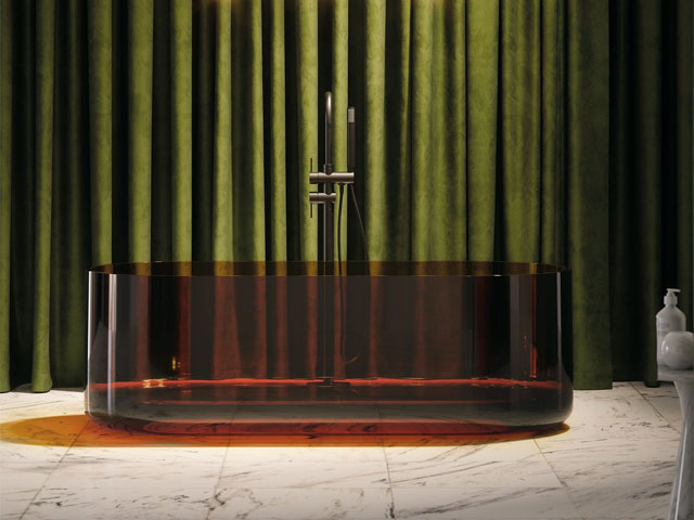 Dark green curtain with floor standing red transparent bathtub on stone floor