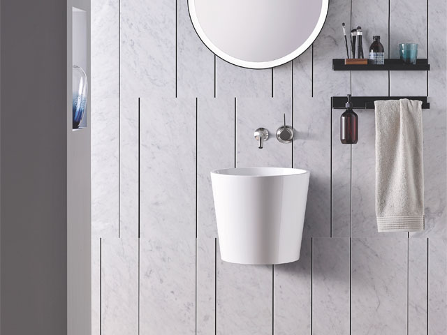 long white wall hung basin with silver taps and circular mirror